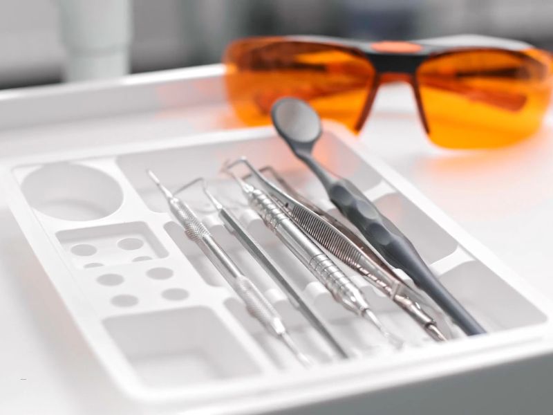 dentalni pribor u posudi , naočare za zubare pored