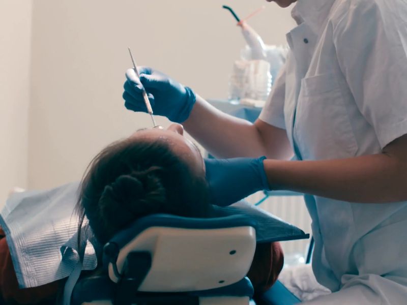 zubarka radi zube osobi koja sedi na stolici