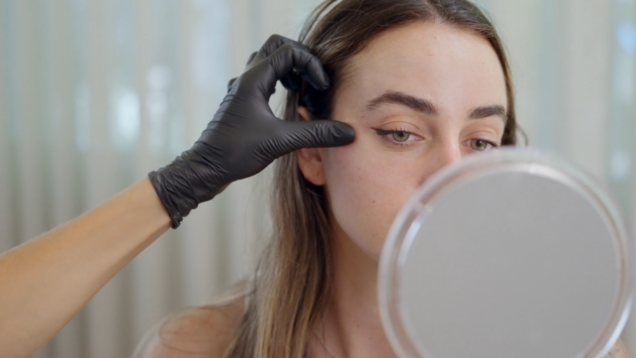 Dermatolog pregleda kožu tinejdžerke tokom pregleda lica